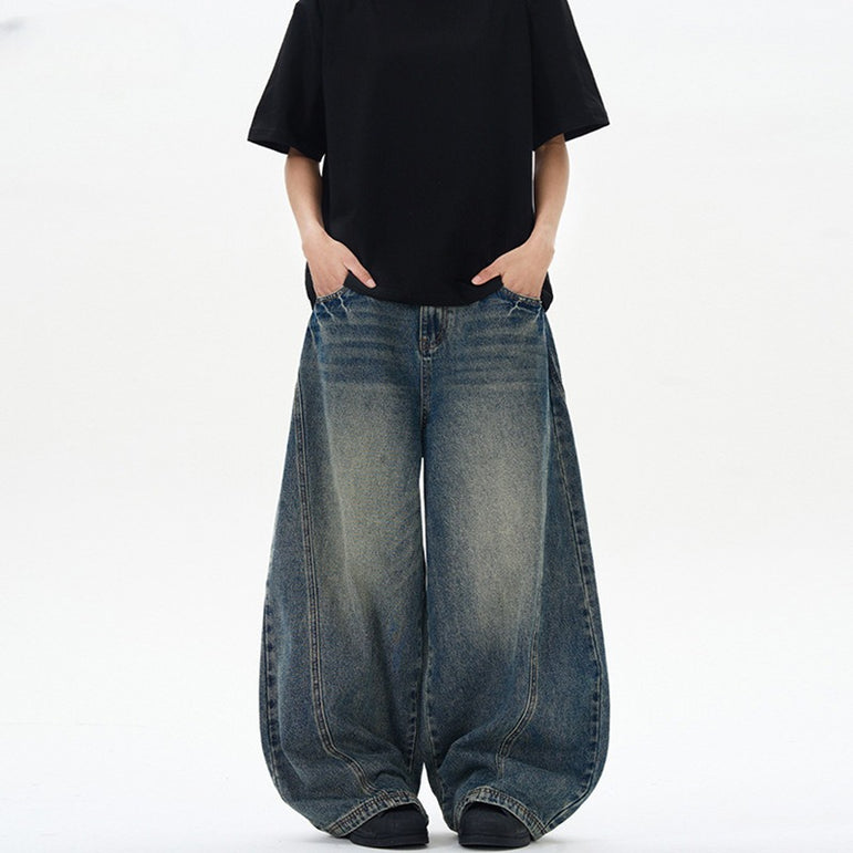 Person wearing wide-leg jeans and a black t-shirt on a white background