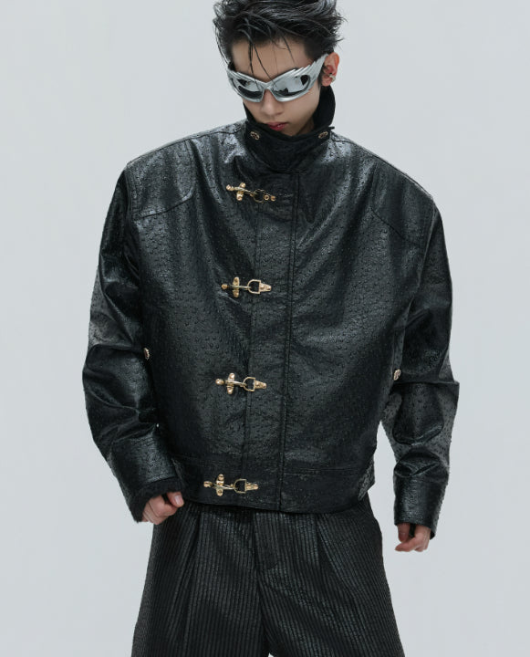 Person wearing a black textured jacket with gold buttons on a light gray background